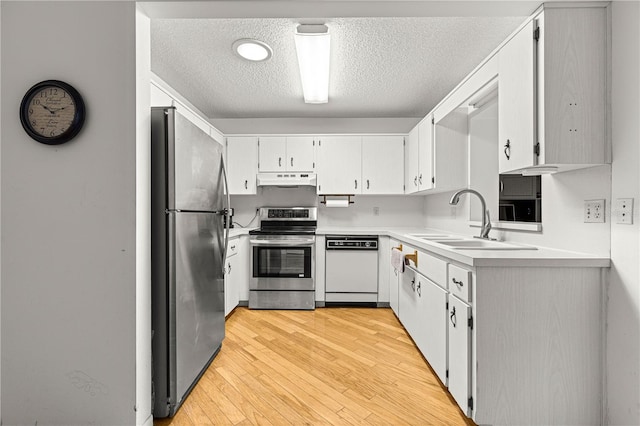 8850 SW 97th St Unit C, Ocala, FL 34481 - kitchen with stainless steel appliances, a textured ceiling, light wood finished floors, light countertops, and under cabinet range hood