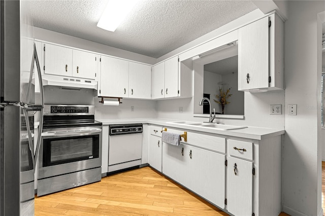 8850 SW 97th St Unit C, Ocala, FL 34481 - kitchen featuring stainless steel appliances, under cabinet range hood, a textured ceiling, light wood finished floors, and light countertops