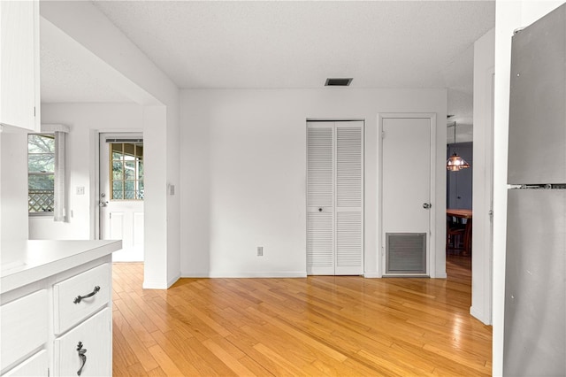 8850 SW 97th St Unit C, Ocala, FL 34481 - unfurnished bedroom featuring freestanding refrigerator and light wood-type flooring