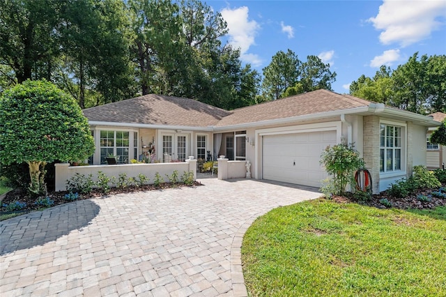 7242 SW 115th Pl, Ocala, FL 34476 - single story home with an attached garage, decorative driveway, a front lawn, and roof with shingles