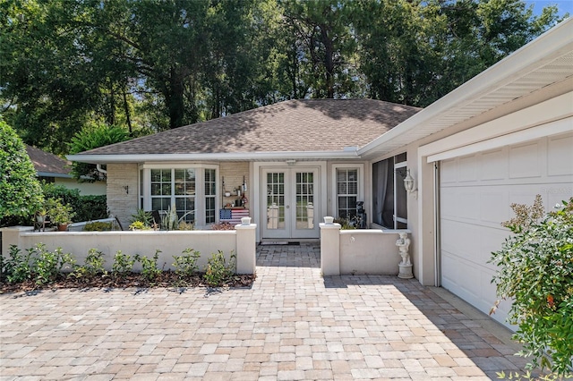 7242 SW 115th Pl, Ocala, FL 34476 - view of front facade featuring french doors, a garage, roof with shingles, and brick siding