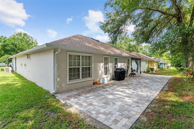 7242 SW 115th Pl, Ocala, FL 34476 - back of property featuring stucco siding, a patio area, a yard, and roof with shingles