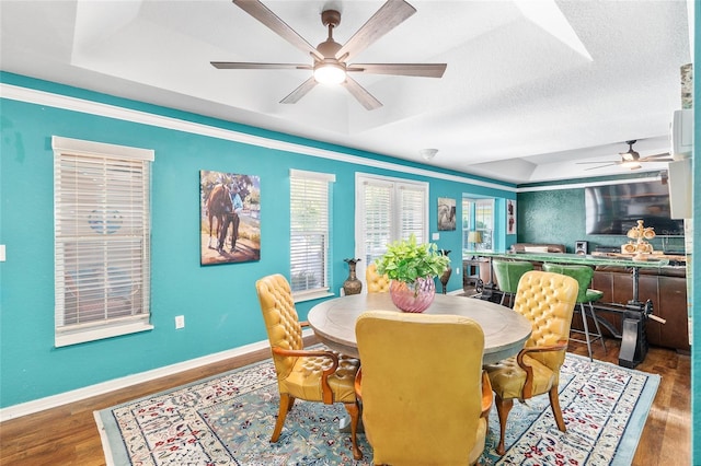 7242 SW 115th Pl, Ocala, FL 34476 - dining space featuring ceiling fan, wood finished floors, and a tray ceiling