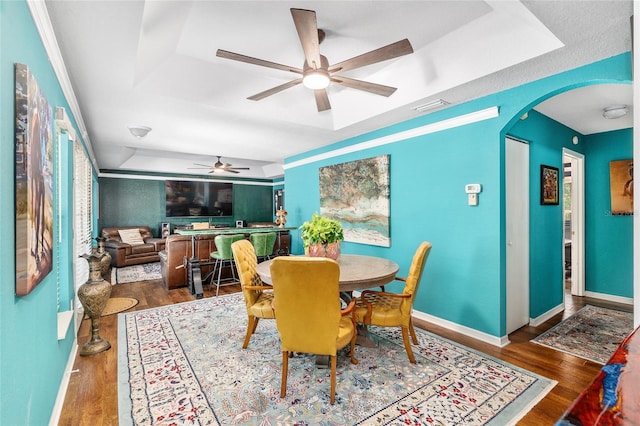 7242 SW 115th Pl, Ocala, FL 34476 - dining room featuring a tray ceiling, ceiling fan, arched walkways, and wood finished floors