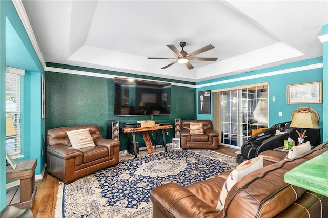 7242 SW 115th Pl, Ocala, FL 34476 - living room featuring a tray ceiling, a ceiling fan, wood finished floors, and crown molding