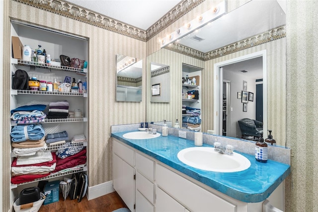 7242 SW 115th Pl, Ocala, FL 34476 - bathroom featuring wallpapered walls, wood finished floors, and double vanity