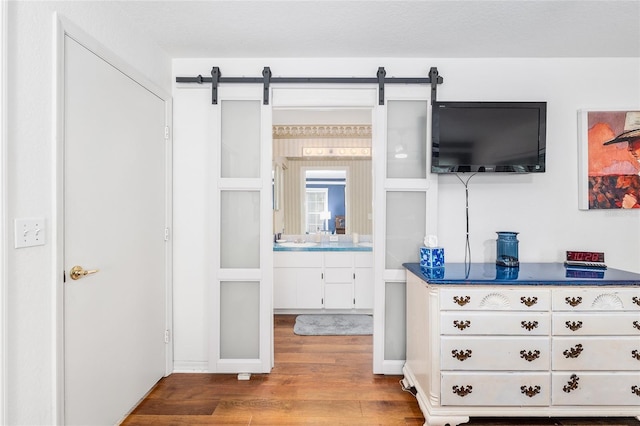 7242 SW 115th Pl, Ocala, FL 34476 - bedroom featuring wood finished floors, a barn door, and connected bathroom