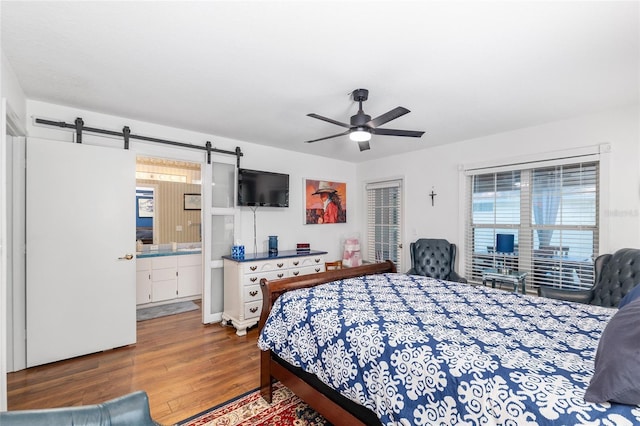 7242 SW 115th Pl, Ocala, FL 34476 - bedroom with wood finished floors, multiple windows, a barn door, and a ceiling fan
