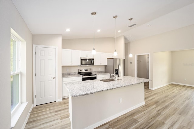 2766 W Santana Dr, Citrus Springs, FL 34433 - kitchen with stainless steel appliances, white cabinets, light wood-style flooring, a center island with sink, and decorative light fixtures