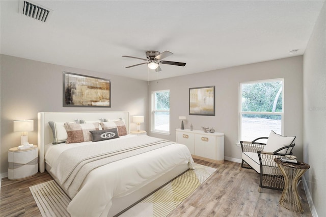 2766 W Santana Dr, Citrus Springs, FL 34433 - bedroom with multiple windows, light wood finished floors, and a ceiling fan