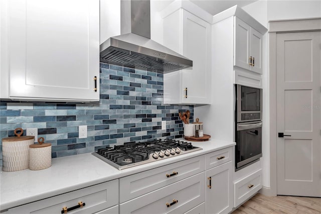 3196 W Mustang Blvd, Beverly Hills, FL 34465 - kitchen featuring wall chimney range hood, appliances with stainless steel finishes, light countertops, and white cabinetry