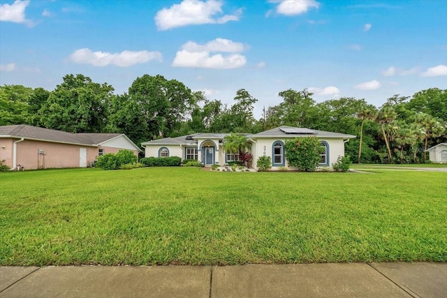 3769 Grove View Ln, Port Orange, FL 32129 - ranch-style house featuring roof mounted solar panels, a front yard, and view of scattered trees