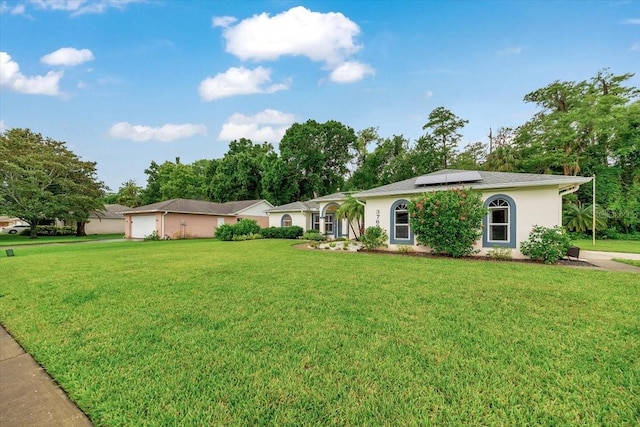 3769 Grove View Ln, Port Orange, FL 32129 - ranch-style home with roof mounted solar panels, a front lawn, stucco siding, and a garage