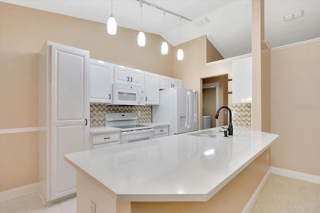 3769 Grove View Ln, Port Orange, FL 32129 - kitchen with white appliances, a peninsula, decorative backsplash, white cabinets, and rail lighting