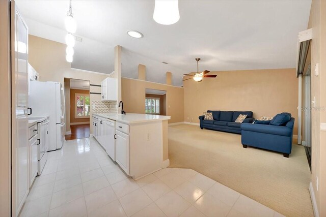 3769 Grove View Ln, Port Orange, FL 32129 - kitchen featuring white appliances, light colored carpet, light countertops, white cabinets, and vaulted ceiling