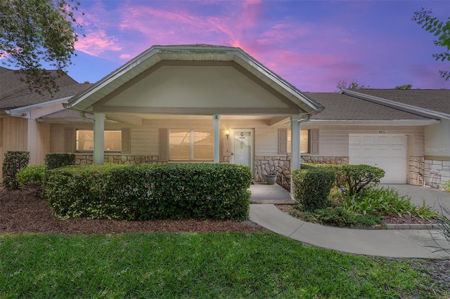 9065 SW 82nd Ter Unit G, Ocala, FL 34481 - view of front of home featuring stone siding, covered porch, a garage, and concrete driveway