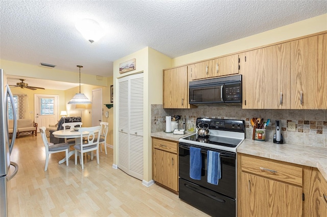 9065 SW 82nd Ter Unit G, Ocala, FL 34481 - kitchen with black appliances, light wood-style flooring, decorative backsplash, light countertops, and a textured ceiling