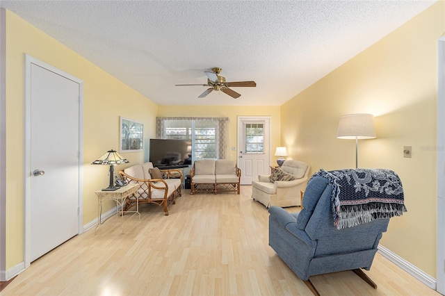 9065 SW 82nd Ter Unit G, Ocala, FL 34481 - living room featuring light wood finished floors, ceiling fan, and a textured ceiling