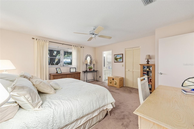 9065 SW 82nd Ter Unit G, Ocala, FL 34481 - bedroom with light carpet, a closet, connected bathroom, ceiling fan, and a textured ceiling