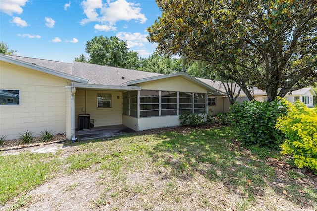 9065 SW 82nd Ter Unit G, Ocala, FL 34481 - rear view of property featuring a sunroom, a shingled roof, a lawn, and concrete block siding