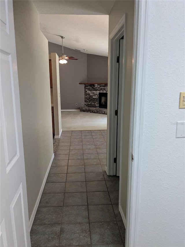 3650 SE 55th Ct, Ocala, FL 34480 - corridor featuring lofted ceiling, dark tile patterned flooring, and a textured ceiling