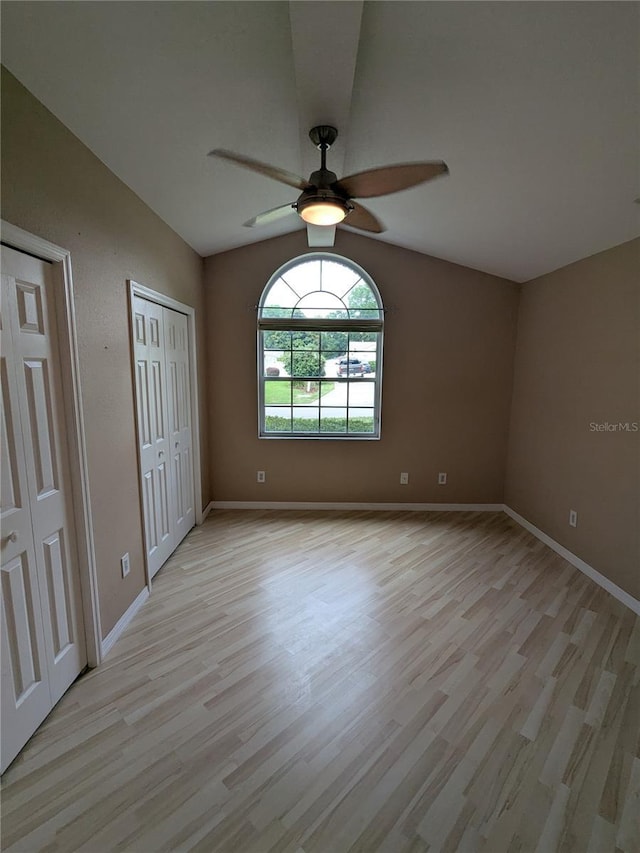 3650 SE 55th Ct, Ocala, FL 34480 - unfurnished bedroom with light wood-style flooring, multiple closets, vaulted ceiling, and ceiling fan