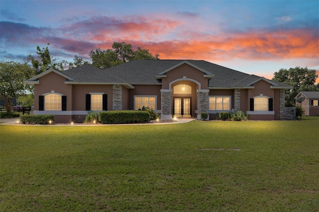 7220 NW 83rd Ter, Ocala, FL 34482 - view of front of home featuring stucco siding, stone siding, french doors, and a lawn