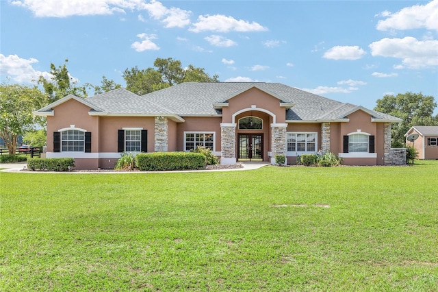 7220 NW 83rd Ter, Ocala, FL 34482 - view of front of house with stucco siding, french doors, stone siding, a front yard, and a shingled roof