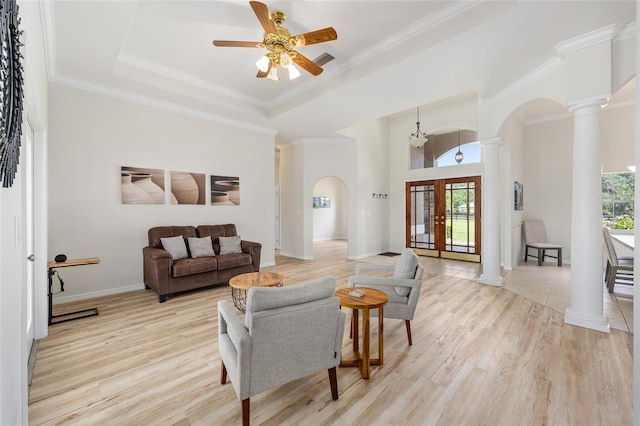 7220 NW 83rd Ter, Ocala, FL 34482 - living room with arched walkways, decorative columns, a ceiling fan, light wood finished floors, and a tray ceiling