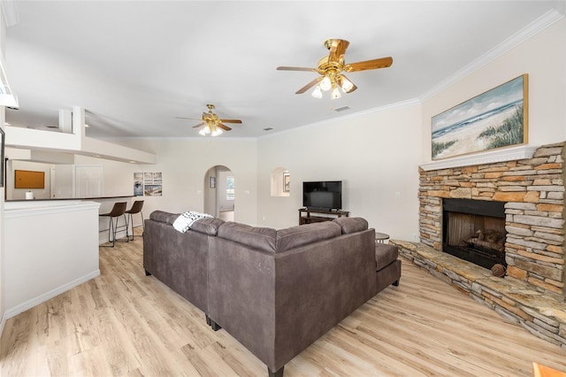7220 NW 83rd Ter, Ocala, FL 34482 - living room with arched walkways, light wood-type flooring, a stone fireplace, ornamental molding, and ceiling fan