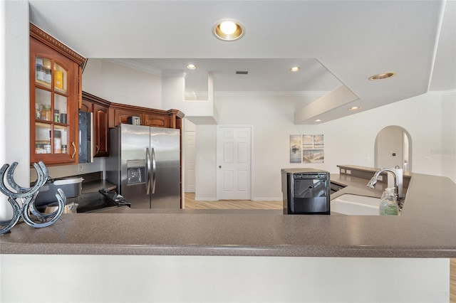 7220 NW 83rd Ter, Ocala, FL 34482 - kitchen featuring stainless steel refrigerator with ice dispenser, crown molding, recessed lighting, glass insert cabinets, and arched walkways
