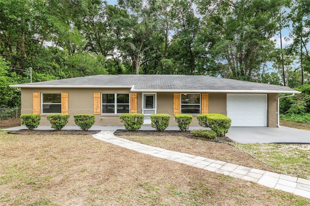 3640 SE 131st Ln, Belleview, FL 34420 - single story home featuring an attached garage, roof with shingles, driveway, stucco siding, and view of scattered trees