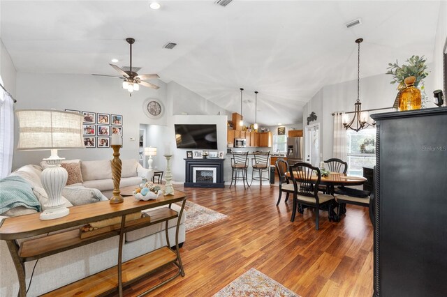 6362 N Walter Ter, Citrus Springs, FL 34434 - living area featuring a ceiling fan, a fireplace, a chandelier, wood finished floors, and high vaulted ceiling