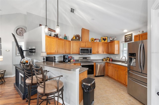 6362 N Walter Ter, Citrus Springs, FL 34434 - kitchen featuring stainless steel appliances, vaulted ceiling, a peninsula, pendant lighting, and a kitchen breakfast bar