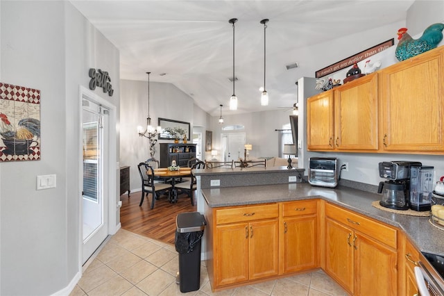 6362 N Walter Ter, Citrus Springs, FL 34434 - kitchen with light tile patterned flooring, a peninsula, dark countertops, vaulted ceiling, and a chandelier