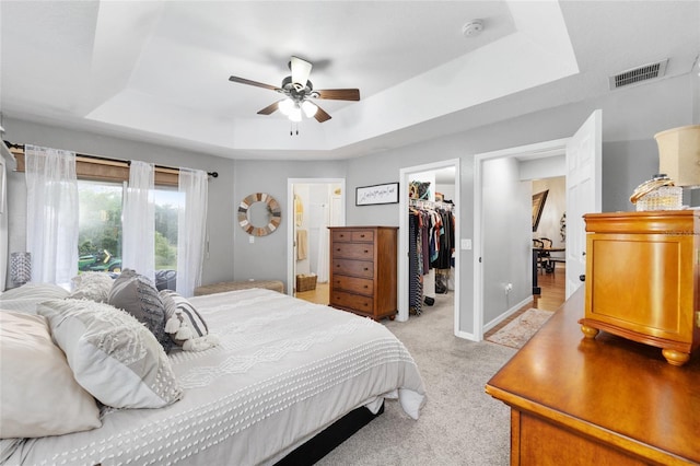 6362 N Walter Ter, Citrus Springs, FL 34434 - bedroom with a tray ceiling, a spacious closet, a closet, light carpet, and a ceiling fan