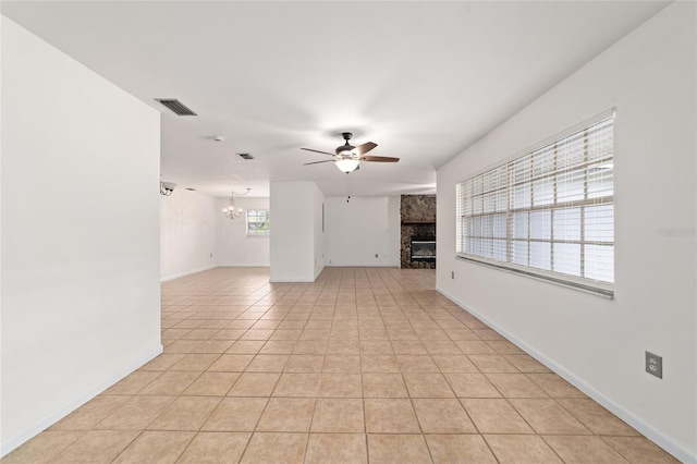 5500 SE 2nd Pl, Ocala, FL 34480 - unfurnished living room featuring a large fireplace, a ceiling fan, a chandelier, and light tile patterned flooring