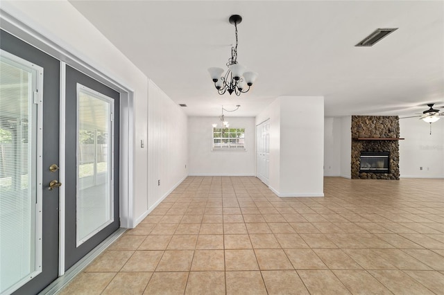 5500 SE 2nd Pl, Ocala, FL 34480 - unfurnished dining area with a chandelier, a stone fireplace, light tile patterned flooring, and a ceiling fan