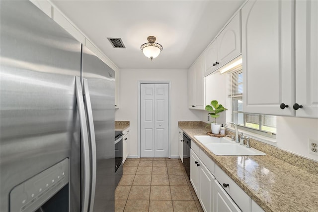 5500 SE 2nd Pl, Ocala, FL 34480 - kitchen with appliances with stainless steel finishes, white cabinets, light tile patterned floors, and light stone countertops