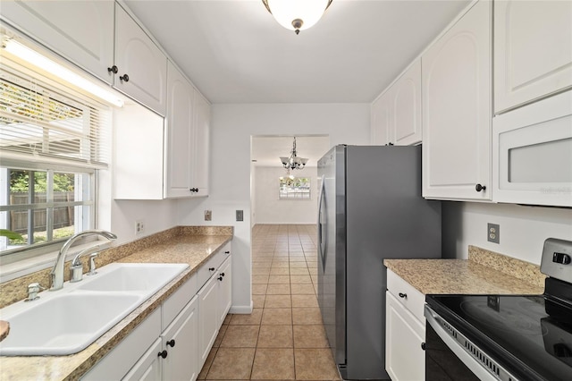 5500 SE 2nd Pl, Ocala, FL 34480 - kitchen with stainless steel appliances, a chandelier, light tile patterned floors, and white cabinetry