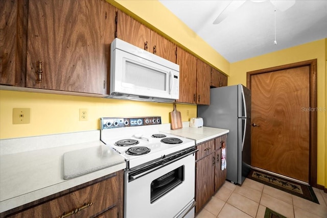 5525 NE 22nd Ave, Ocala, FL 34479 - kitchen featuring white appliances, light countertops, light tile patterned floors, brown cabinets, and ceiling fan