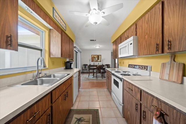 5525 NE 22nd Ave, Ocala, FL 34479 - kitchen featuring white appliances, light tile patterned flooring, light countertops, a ceiling fan, and brown cabinets