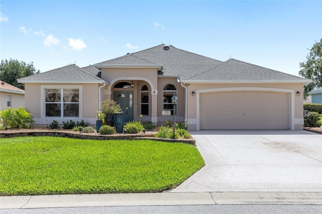7243 SE 172nd Legacy Ln, The Villages, FL 32162 - view of front of property with an attached garage, a front lawn, stucco siding, and concrete driveway