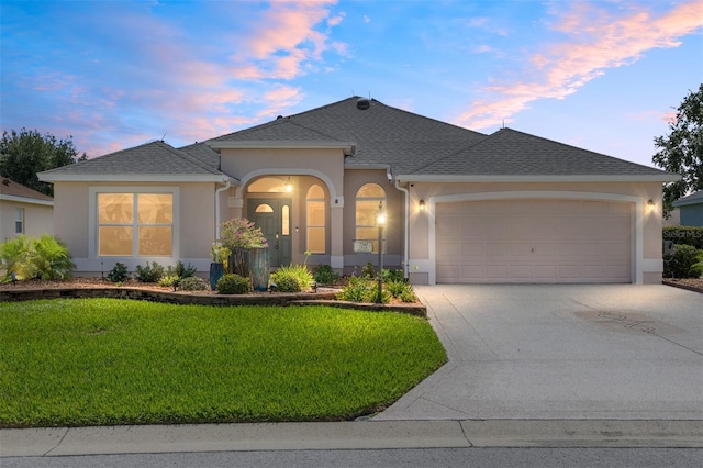 7243 SE 172nd Legacy Ln, The Villages, FL 32162 - view of front facade with a garage, driveway, stucco siding, a front lawn, and a shingled roof