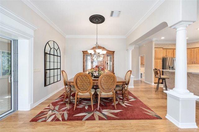 7243 SE 172nd Legacy Ln, The Villages, FL 32162 - dining room with decorative columns, light wood-style flooring, a chandelier, and crown molding
