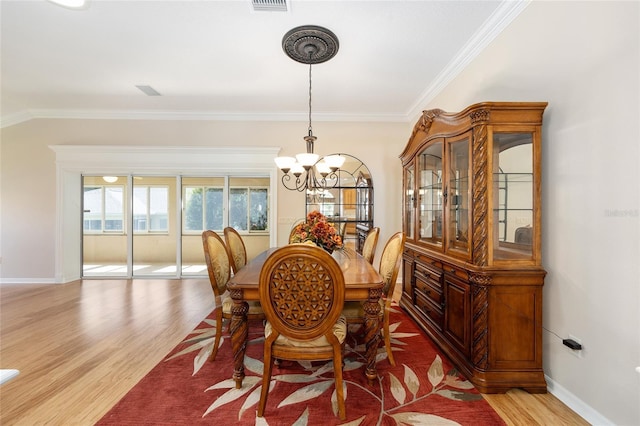 7243 SE 172nd Legacy Ln, The Villages, FL 32162 - dining space with a chandelier, ornamental molding, and light wood finished floors