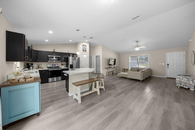 13479 SW 100th Ln, Dunnellon, FL 34432 - kitchen with stainless steel appliances, lofted ceiling, open floor plan, light countertops, and light wood-type flooring