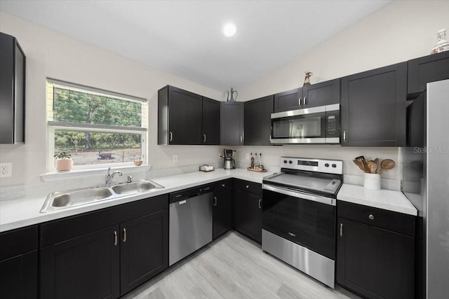 13479 SW 100th Ln, Dunnellon, FL 34432 - kitchen featuring appliances with stainless steel finishes, lofted ceiling, light countertops, dark cabinets, and light wood-style flooring
