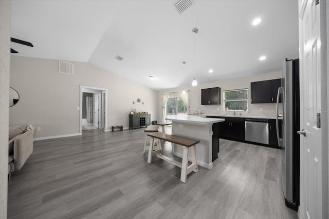 13479 SW 100th Ln, Dunnellon, FL 34432 - kitchen featuring stainless steel appliances, open floor plan, vaulted ceiling, light countertops, and dark cabinetry