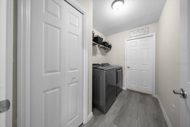 13479 SW 100th Ln, Dunnellon, FL 34432 - laundry room with washing machine and dryer, light wood-style flooring, and a textured ceiling